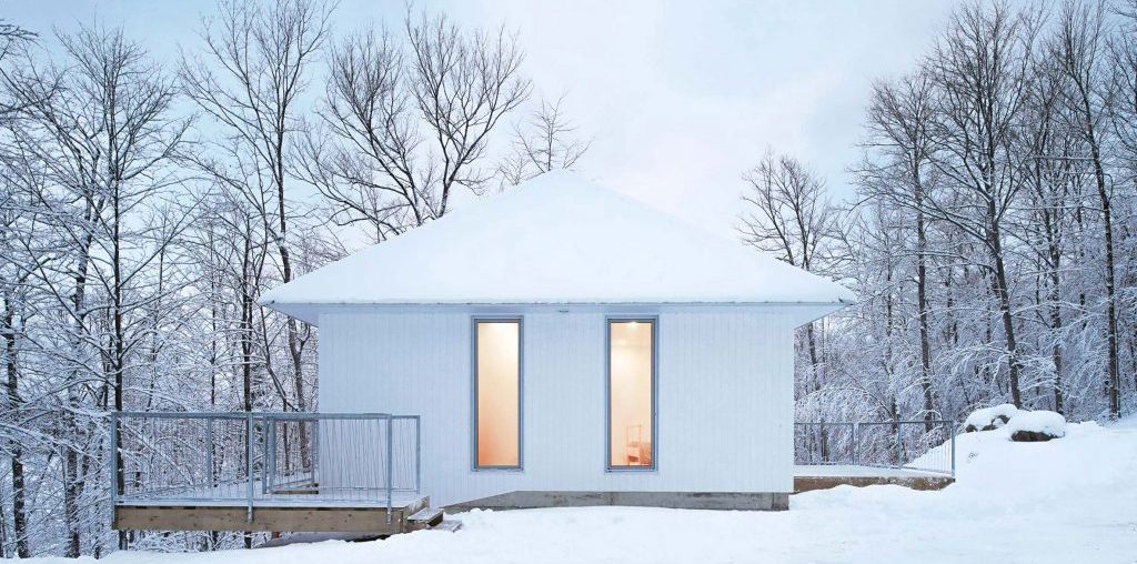 Poisson Blanc cabin by Naturehumaine has a white pointed metal roof