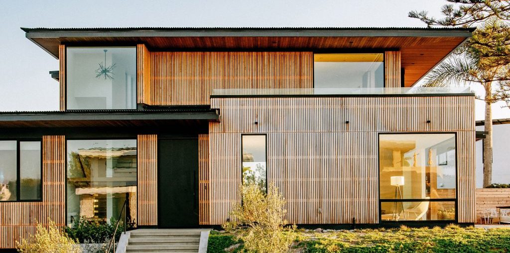 Overhanging roofs shade outdoor areas of cedar-clad Seaside Reef House
